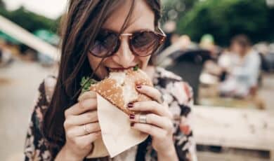 Frau isst Burger auf Food Festival