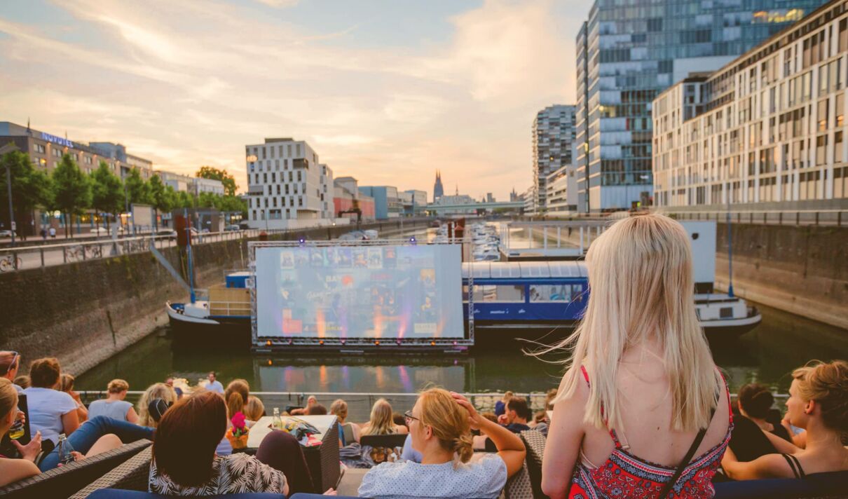 Das Foto zeigt die schwinmende Leinwand des openair Sommerkinos im Kölner Rheinauhafens.