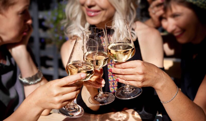 3 Frauen stoßen mit Wein an