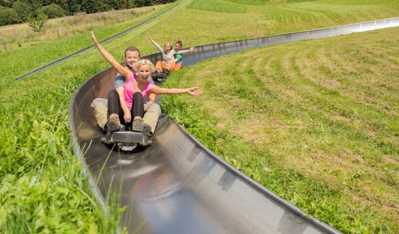 Paar auf einer Sommerrodelbahn im Panoramapark