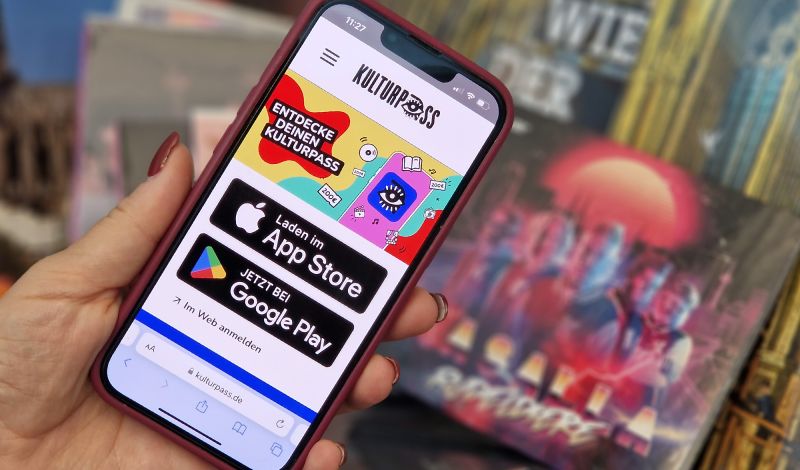 Ein Smartphone mit der Website für den Kulturpass wird in der Hand gehalten