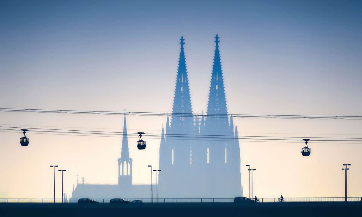 Gondeln der Kölner Seilbahn, im Hintergrund die Silhouette des Kölner Doms.