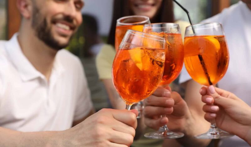 Menschen stoßen mit Aperol Spritz an