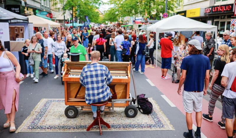 Auf dem Ehrenfelder Straßenfest spielt ein Mann Klavier auf der Venloer Straße.