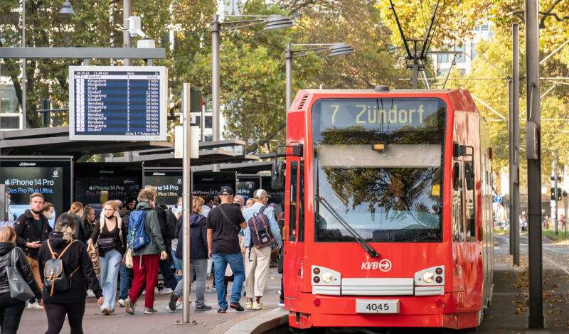 Fahrgäste betreten eine KVB-Stadtbahn der Linie 7, die an einer Haltestelle steht.