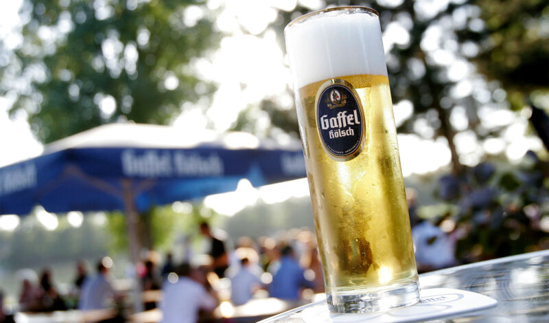 Ein Glas Kölsch von Gaffel, im Hintergrund der Biergarten am Aachener Weiher