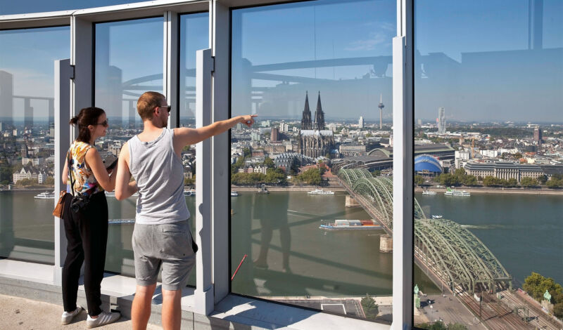 Zwei Touristen genießen den Blick von der Aussichtsplattform des Köln-Triangles auf der rechten Rheinseite