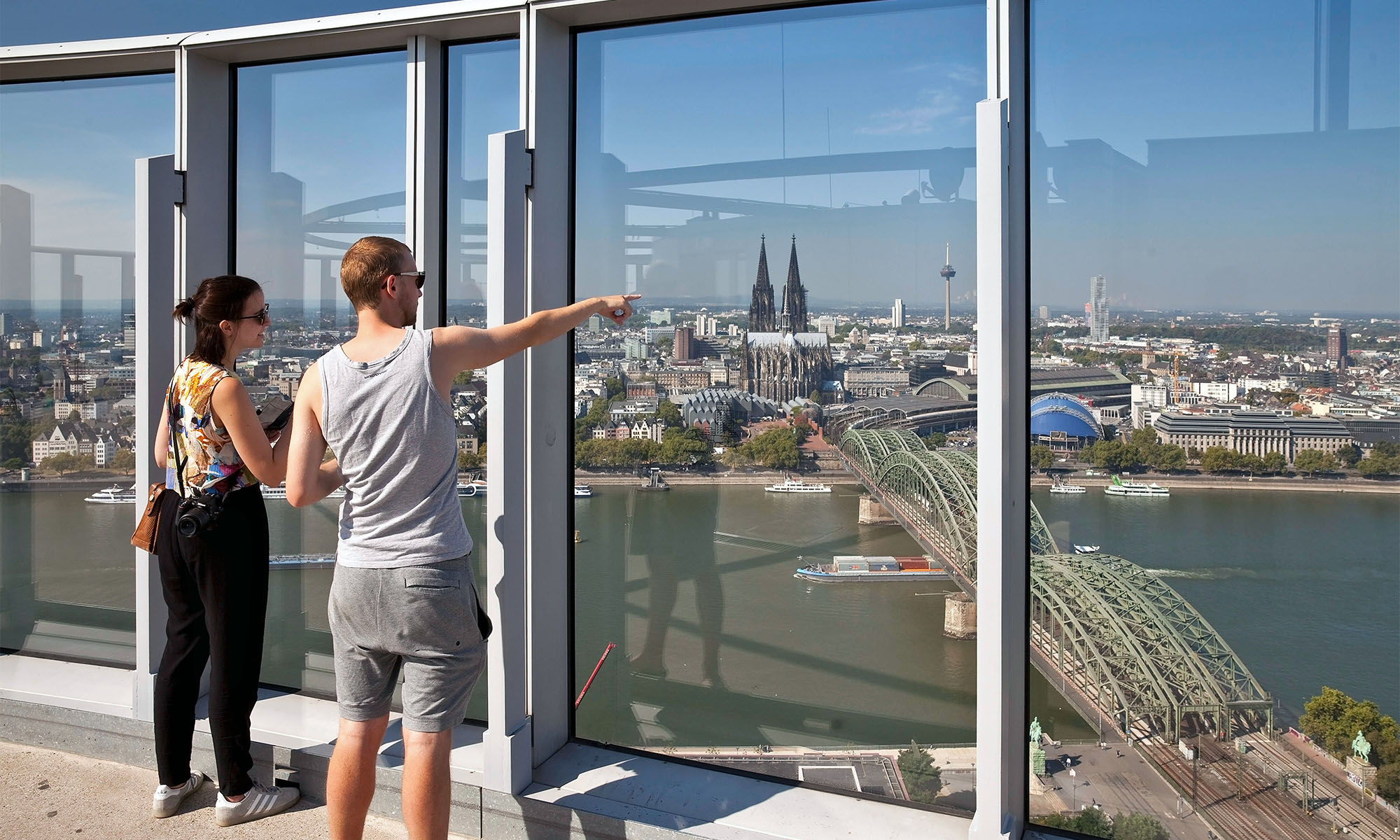 Zwei Touristen genießen den Blick von der Aussichtsplattform des Köln-Triangles auf der rechten Rheinseite