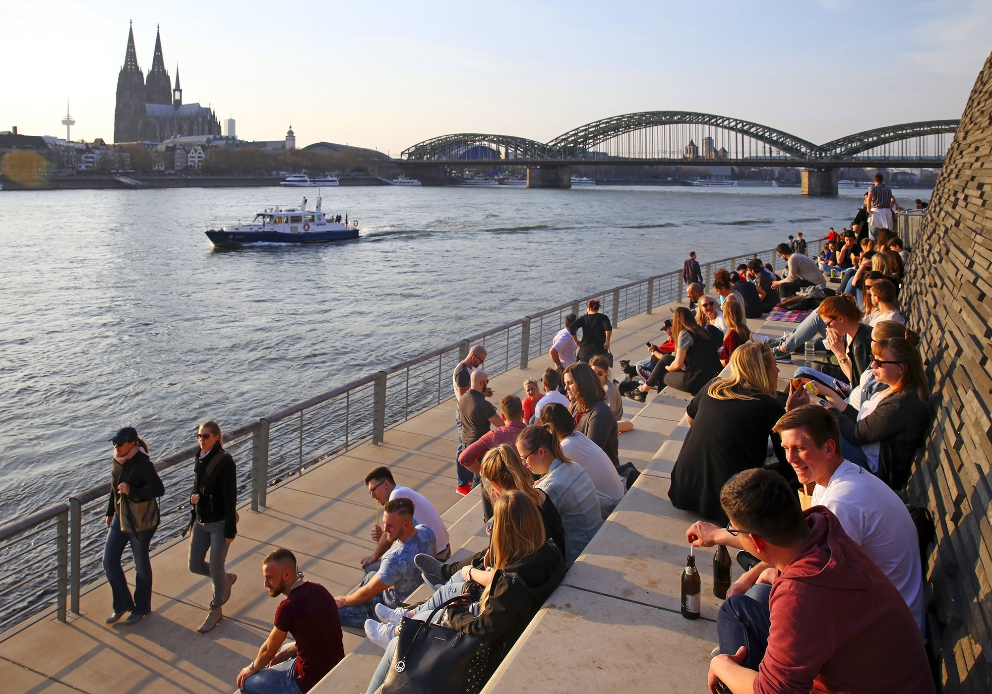 Menschen auf dem Kölner Rheinboulevard.