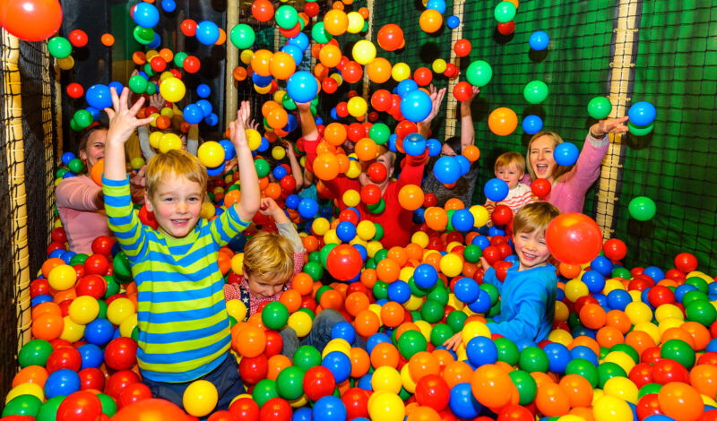 Ein Kind im Bällebad in einem Indoor-Spielplatz