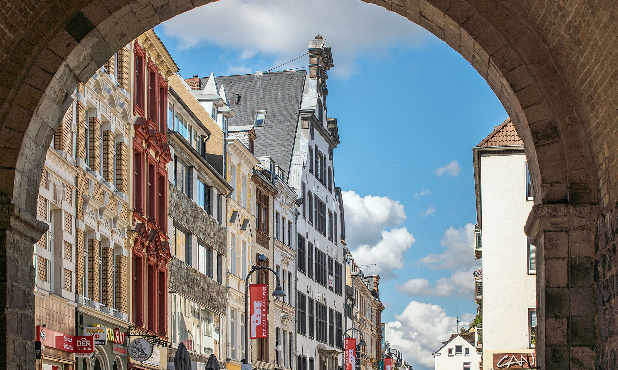 Blick durch die Severinstorburg auf Häuserfassaden in der Kölner Südstadt