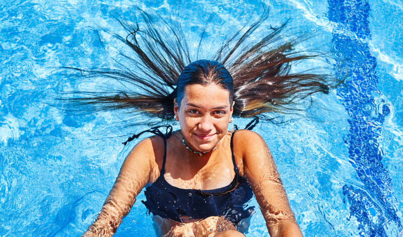 Das Bilder zeigt ein Mädchen, auf dem Rücken liegend, im Schwimmbecken.
