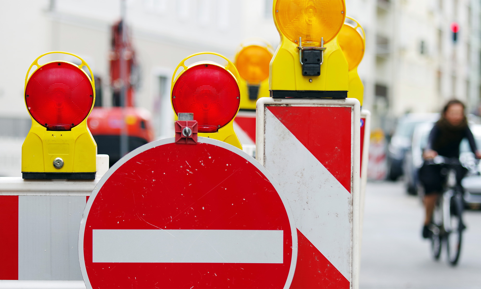 Warnbaken und ein Einbahnstraßenschild weisen auf eine gesperrte Straße hin.