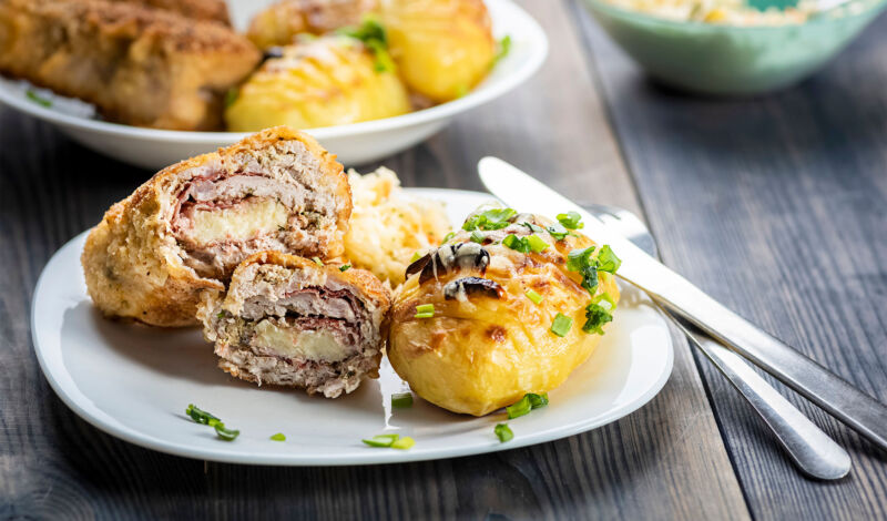 Ein Teller mit Stücken vom Cordon bleu sowie gegrillte Kartoffeln