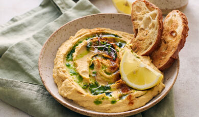 Hummus mit Öl, Zitrone und geröstetem Brot.