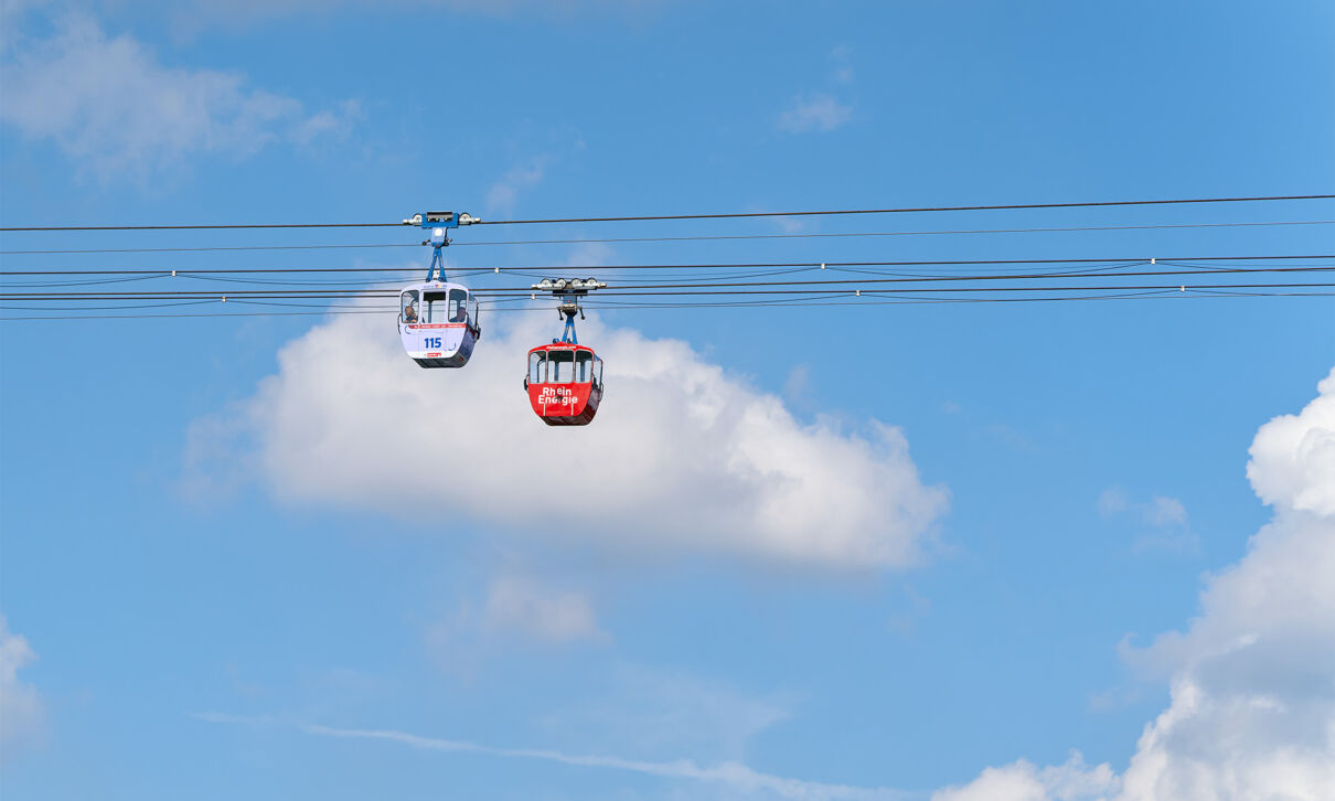 Zwei Gondeln der Kölner Seibahn vor blauem Himmel