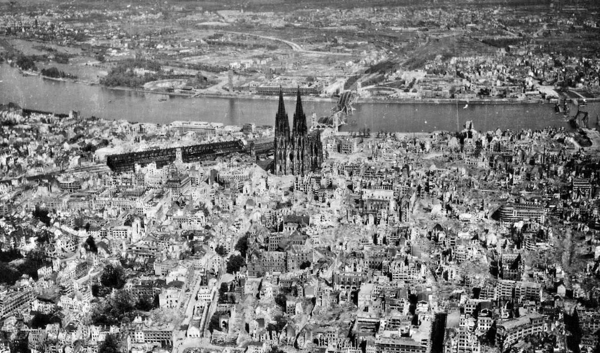 Das Luftbild zeigt ein durch den zweiten Weltkrieg zerstörtes Köln, zwischen den Ruinen steht der kaum beschädigte Kölner Dom.