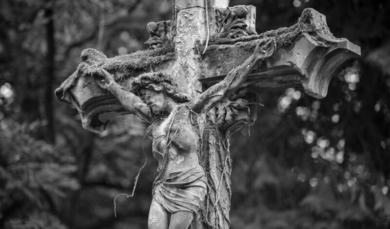 Das Schwarzweißbild zeigt ein Grabkreuz auf dem Kölner Melatenfriedhof.