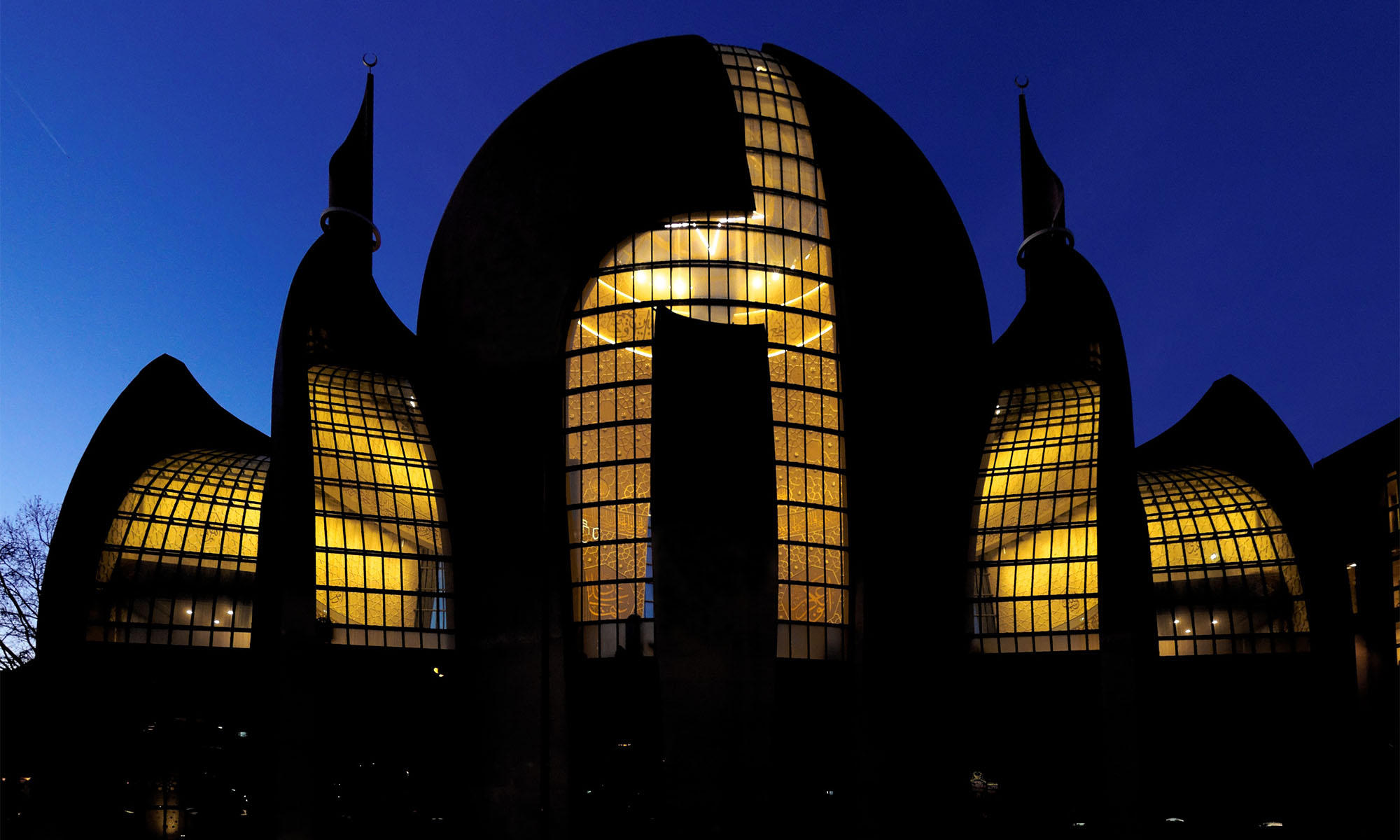 Die beleuchtete Kuppel der Kölner Großmoschee bei Nacht