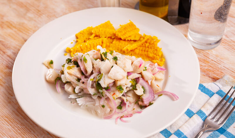 Ceviche, eine Fischspeise der lateinamerikanischen Küche, mit Mais