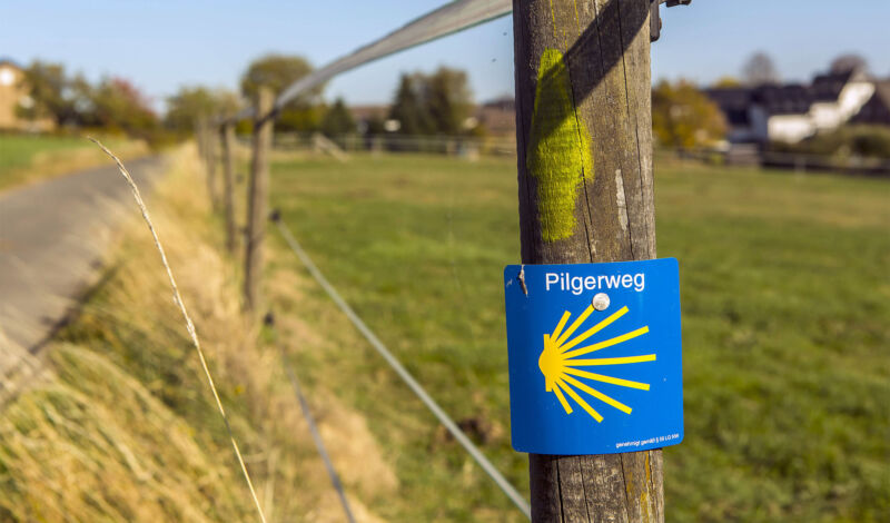 Zeichen und Wegweiser des Jakobsweges an einem Wanderweg