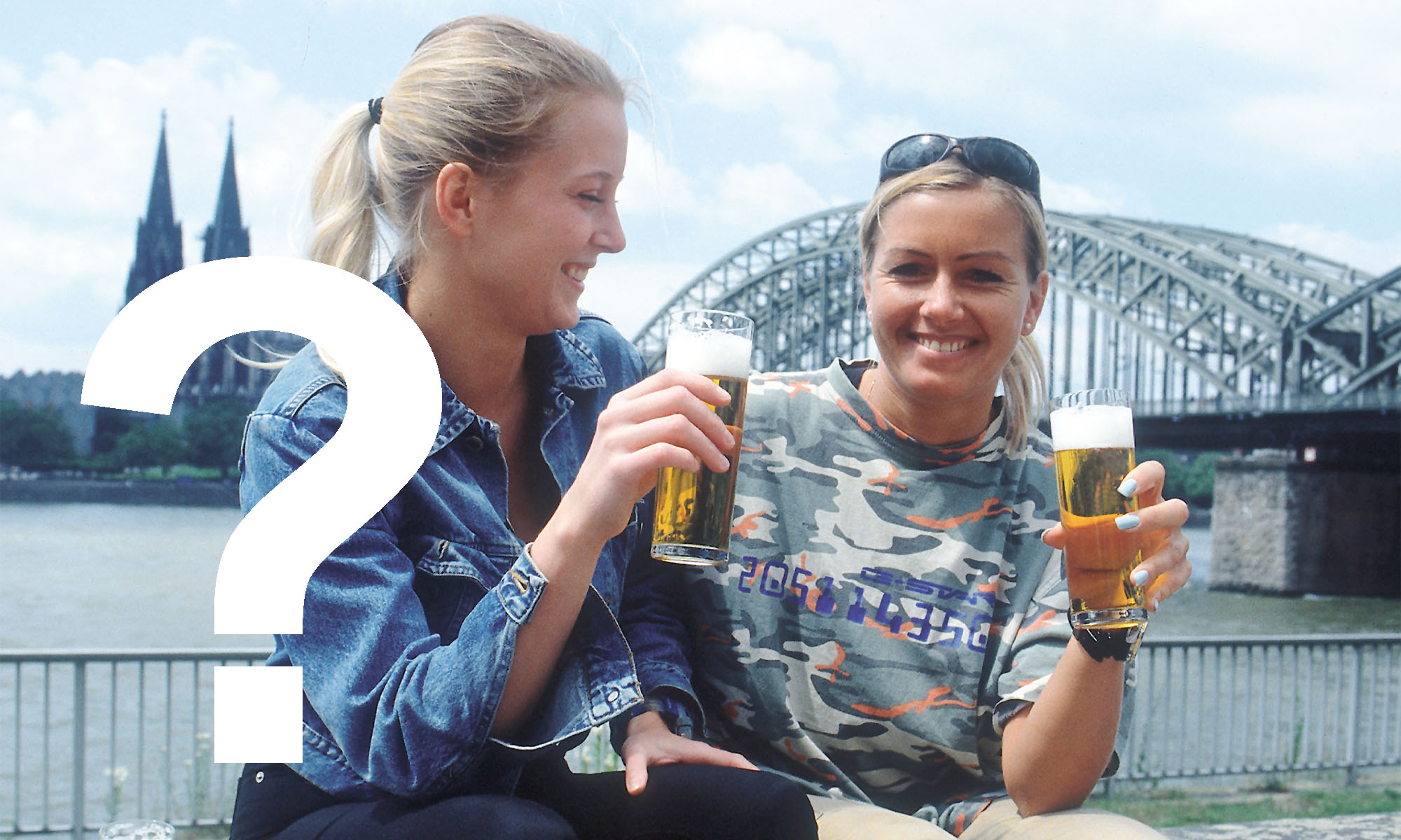 Zwei Frauen stoßen mit Kölsch im Glas an.