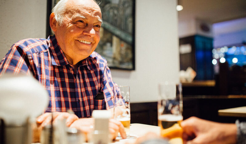 Ein Mann sitzt mit einem Glas Kölsch an einem Tisch in einer Kneipe