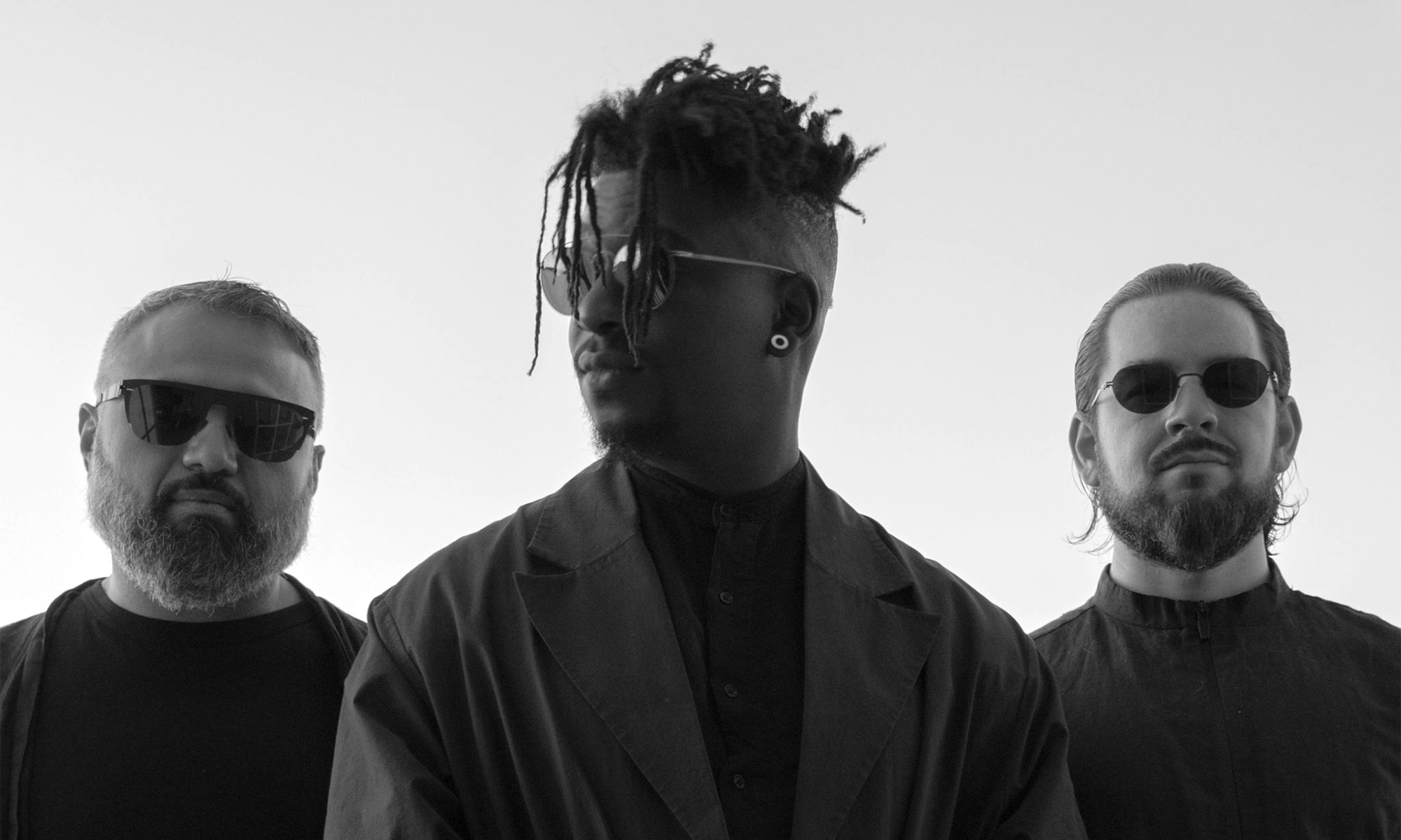 Die drei Musiker des Progressive-Metal-Band Animals as Leaders als Silhouette zu sehen.