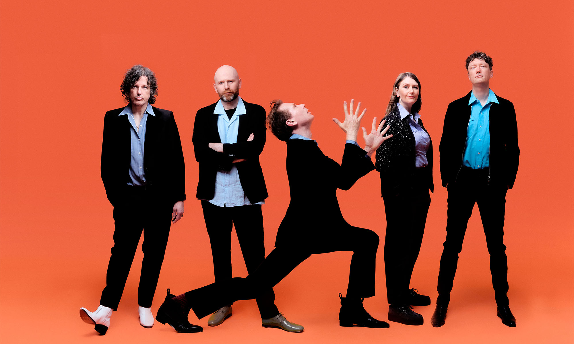 Die Mitglieder der britischen Band Franz Ferdinand vor einem orangefarbenen Hntergrund