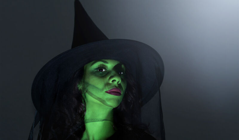 Eine Frau, verkleidet als Elphaba, die böse Hexe des Westens, aus dem Musical Wicked mit grünem Gesicht.