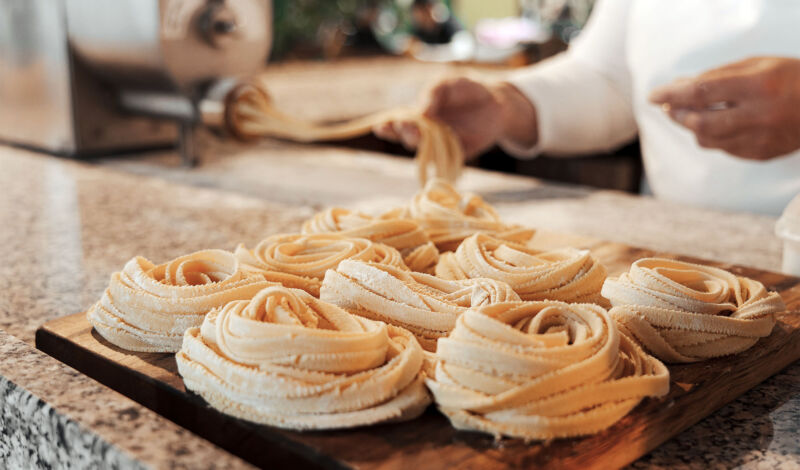 Selbstgemachte Pasta Tagliatelle liegen auf einer Arbeitsfläche