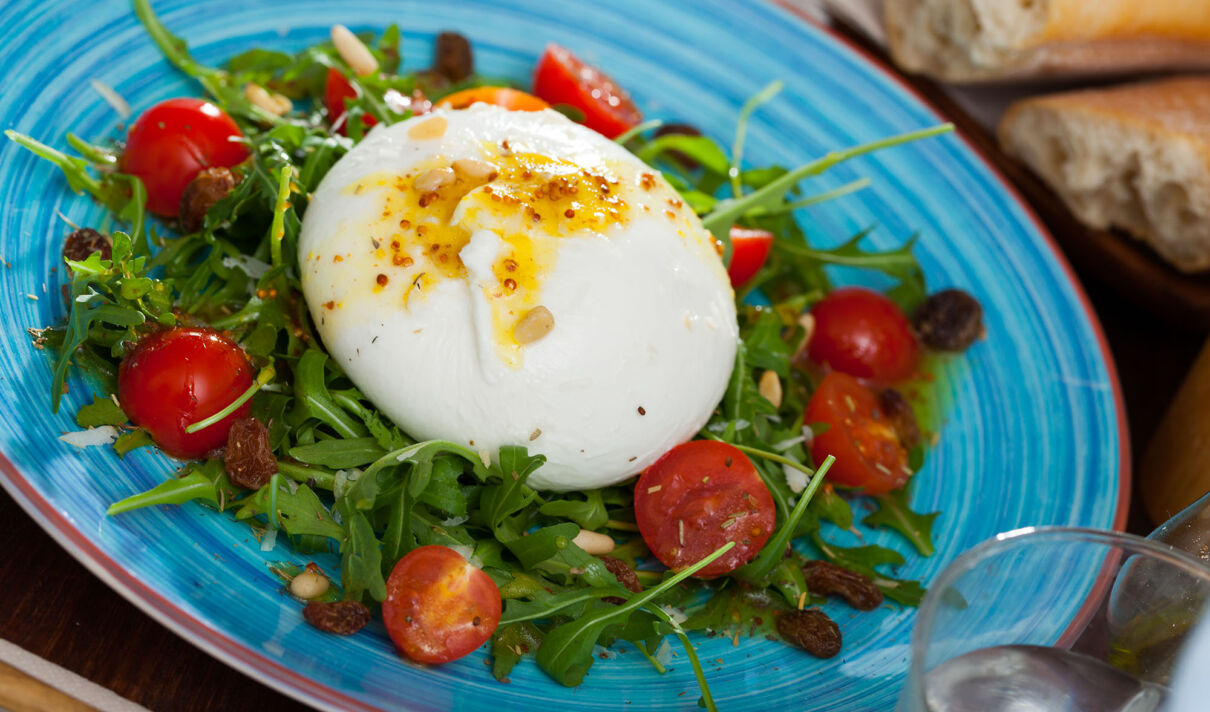 Burrata auf einem Bett von Rucola mit Kirschtomaten