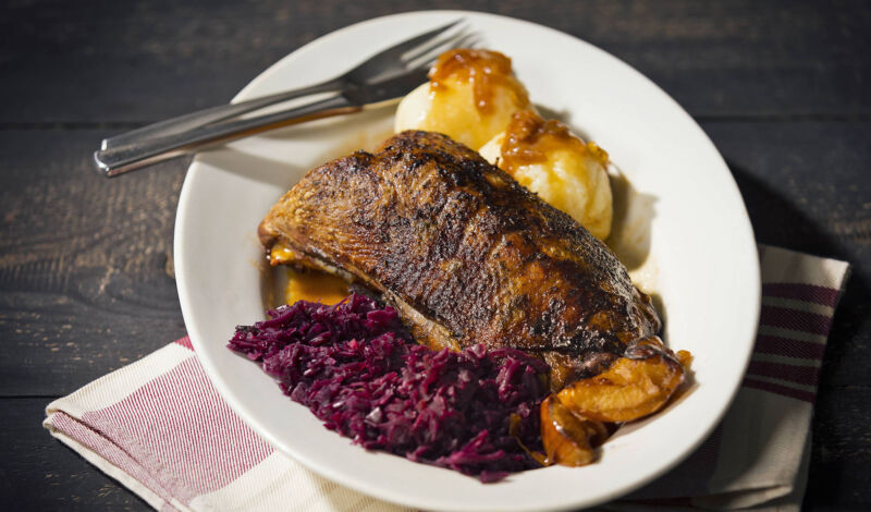 Gebratene Ente mit Rotkohl und Klößen mit Soße.