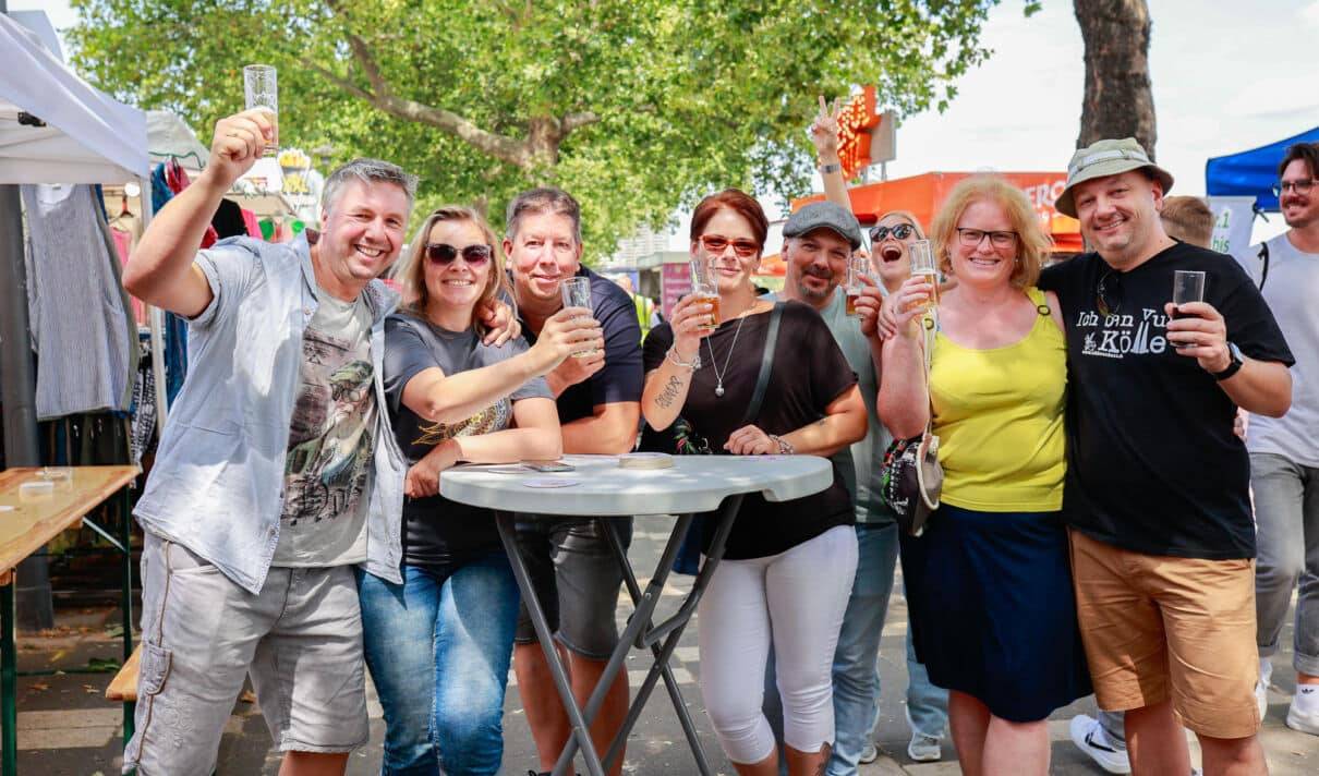Menschen mit Getränken auf dem Rheinuferfest in Köln.